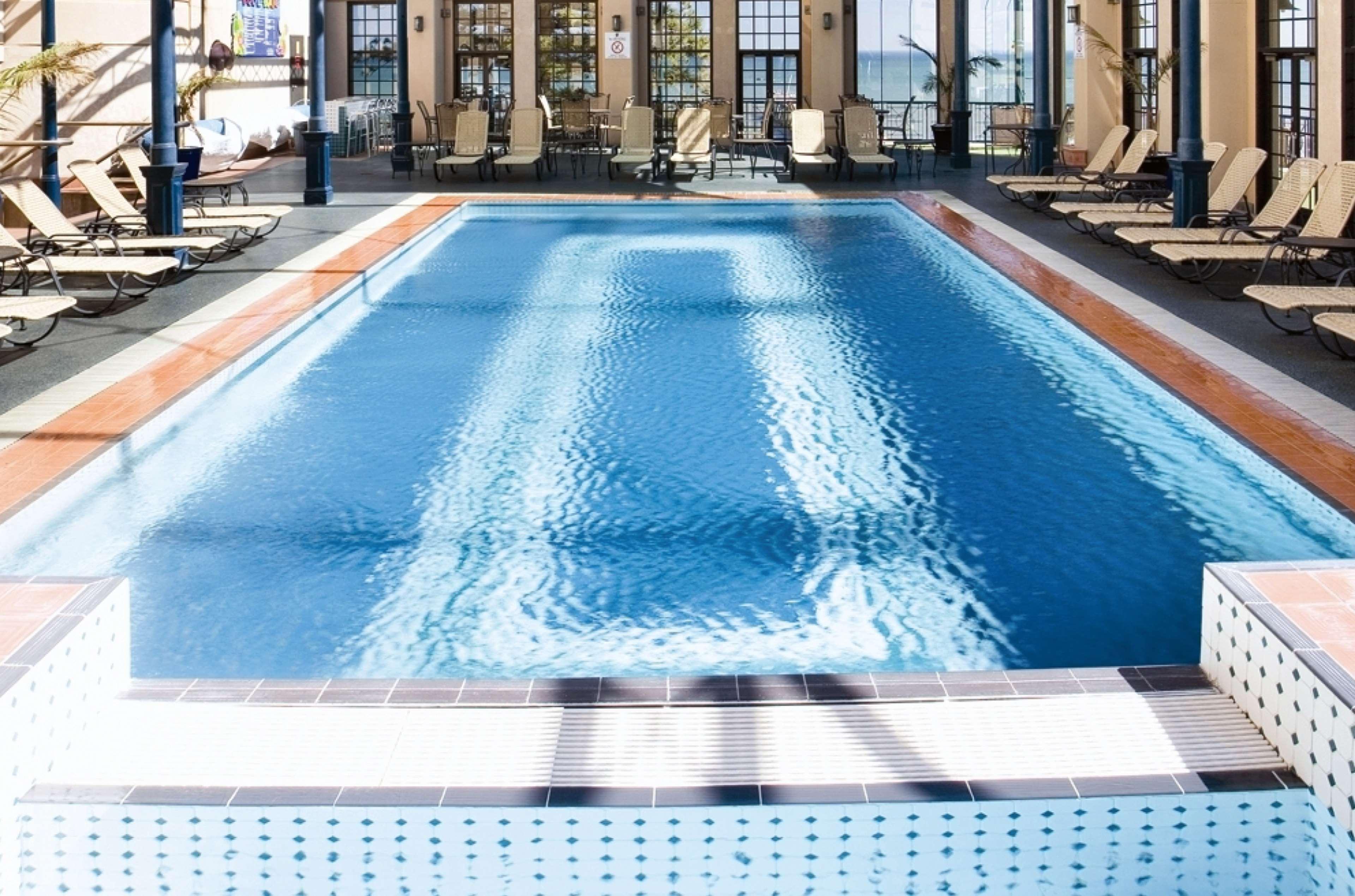 Stamford Grand Adelaide Hotel Glenelg Exterior foto The photo shows an indoor swimming pool with a pristine blue surface. The pool is surrounded by a tiled deck and has lounge chairs lined up along the sides. Large windows allow natural light to flood the area, creating a bright and inviting atmospher