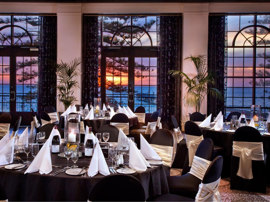 Stamford Grand Adelaide Hotel Glenelg Exterior foto The photo shows an elegant dining setup inside a venue with large windows. The tables are adorned with black tablecloths and white napkins arranged in a stylish manner. Each table has glassware and other dining utensils placed neatly. In the backgrou